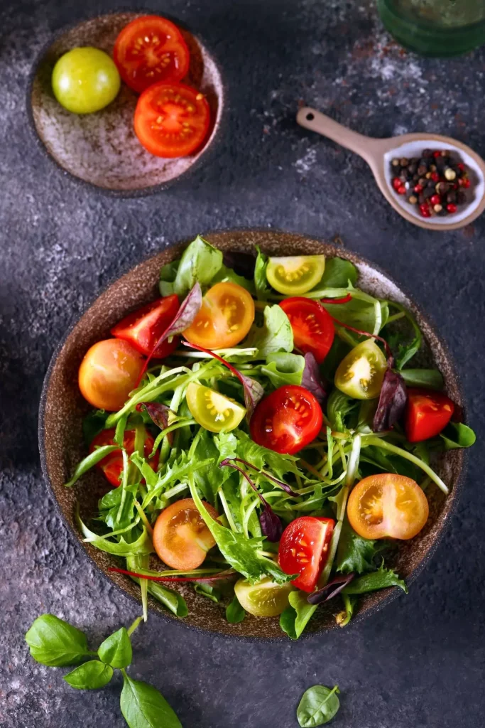 A vibrant bowl of cherry tomato salad featuring halved cherry tomatoes, fresh herbs, and a light vinaigrette.