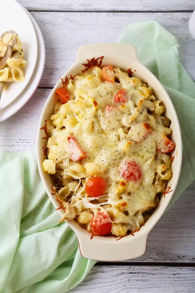 A baked casserole dish of Pasta Fagioli al Forno, topped with melted fontina and sprinkled with fresh parsley.