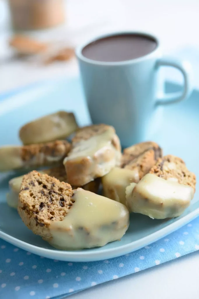 A tray of golden-brown holiday biscotti with almonds and dried fruits, perfect for enjoying with a hot cup of coffee during the holidays.