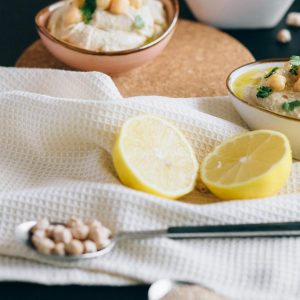 Sliced Lemon on White Textile Near Hummus on Bowls