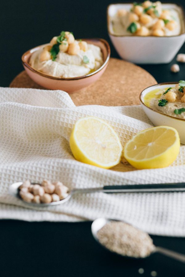 Sliced Lemon on White Textile Near Hummus on Bowls