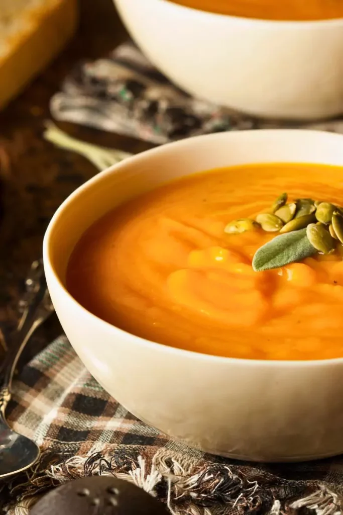 A creamy golden butternut squash custard casserole in a serving dish, topped with a light dusting of cinnamon and nutmeg, served warm.