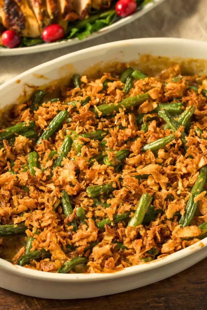 A serving of green beans topped with crispy french-fried onions, served in a baking dish.