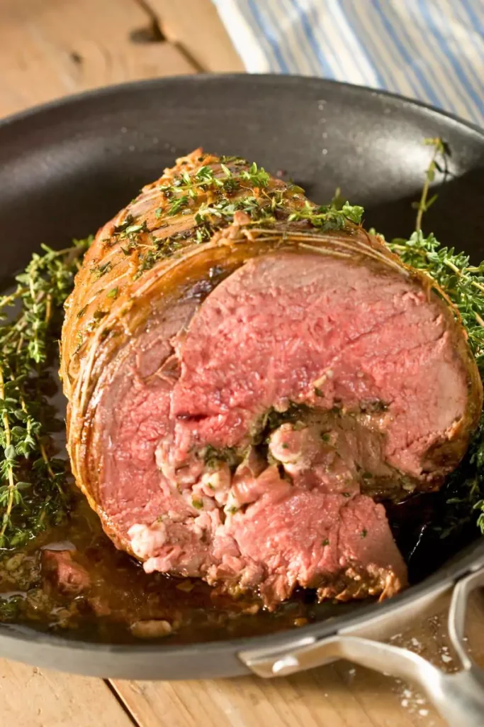 Herb-crusted prime rib roast, freshly sliced, served with au jus sauce