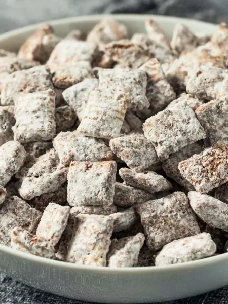 A close-up view of delicious Puppy Chow Truffles dusted with powdered sugar