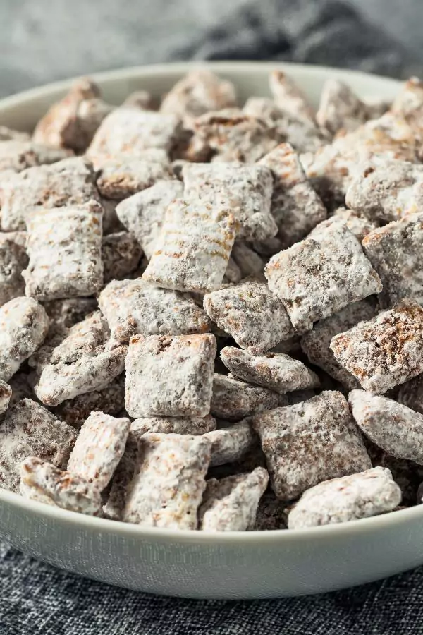 A close-up view of delicious Puppy Chow Truffles dusted with powdered sugar