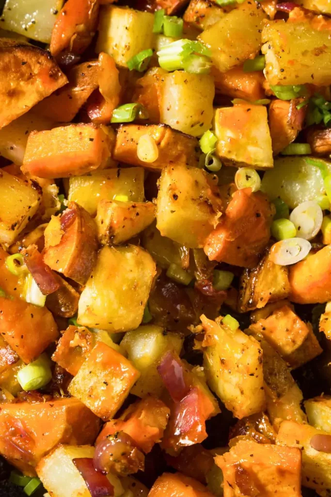 A bowl of Sweet Potato Pilaf garnished with fresh parsley, featuring tender sweet potatoes, vibrant asparagus, crispy bacon.